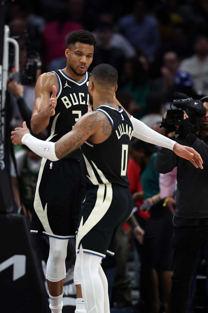 Milwaukee Bucks forward Giannis Antetokounmpo (34) celebrates with guard Damian Lillard (0)